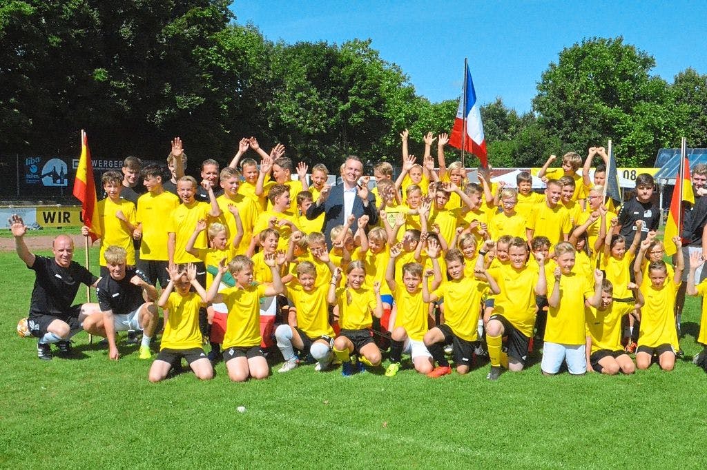 Gruppenbild mit Trainern, Betreuern und Teilnehmern sowie Bürgermeister Manfred Kluthe im Anzug mitten unter den Spielern.